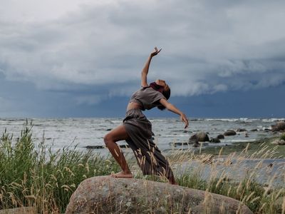 Person in a fluid motion pose against a dark background.